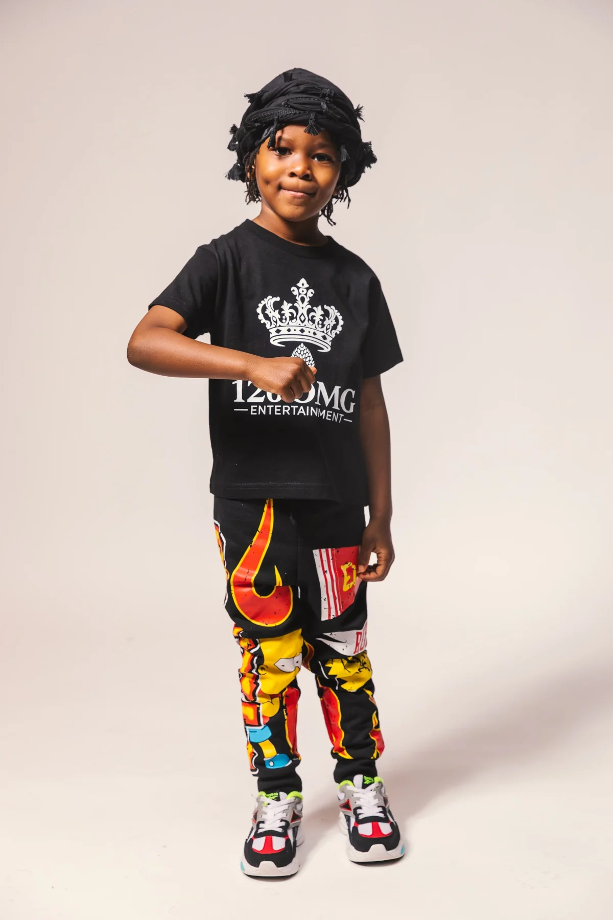 A son in a 126 OMG Entertainment shirt and brightly patterned trousers